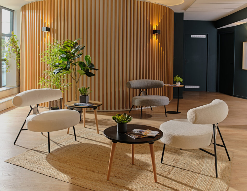 Espace lounge avec fauteuils et mur en tasseaux de bois