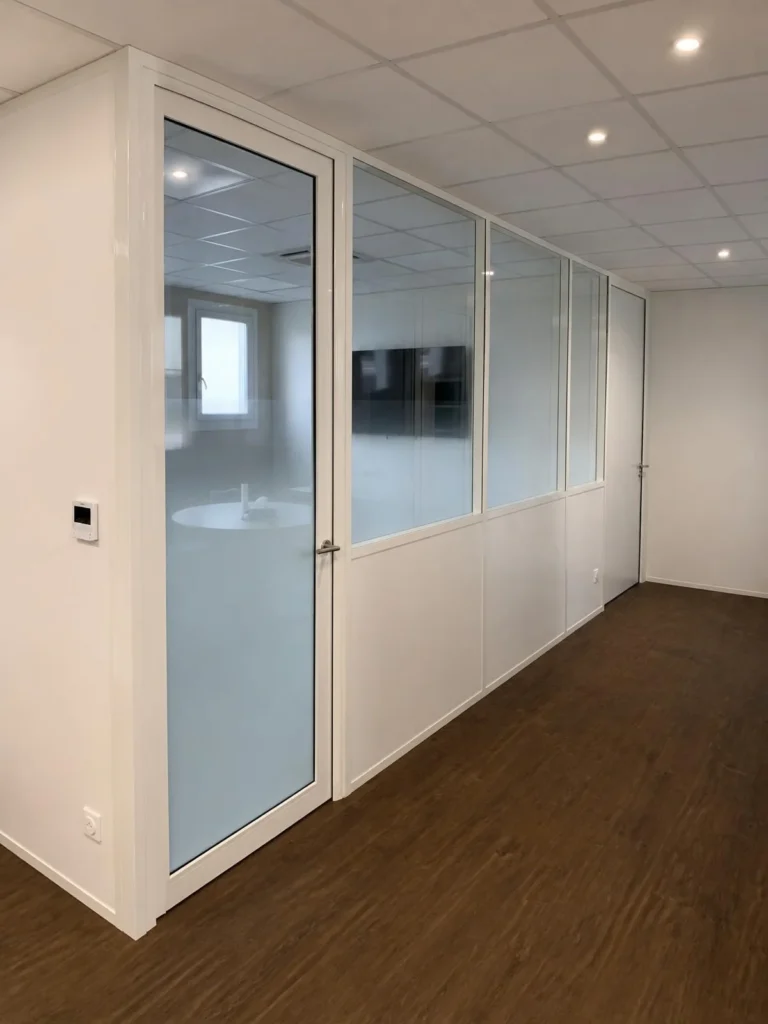 Couloir de bureaux avec cloisons vitrées et sol en parquet